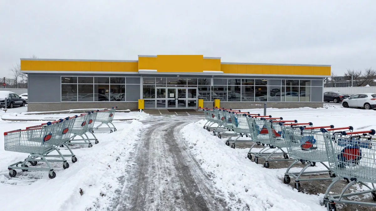 Teilweise geräumter Parkplatz vor einem Supermarkt im Winter – Winterdienst für Gewerbeflächen
