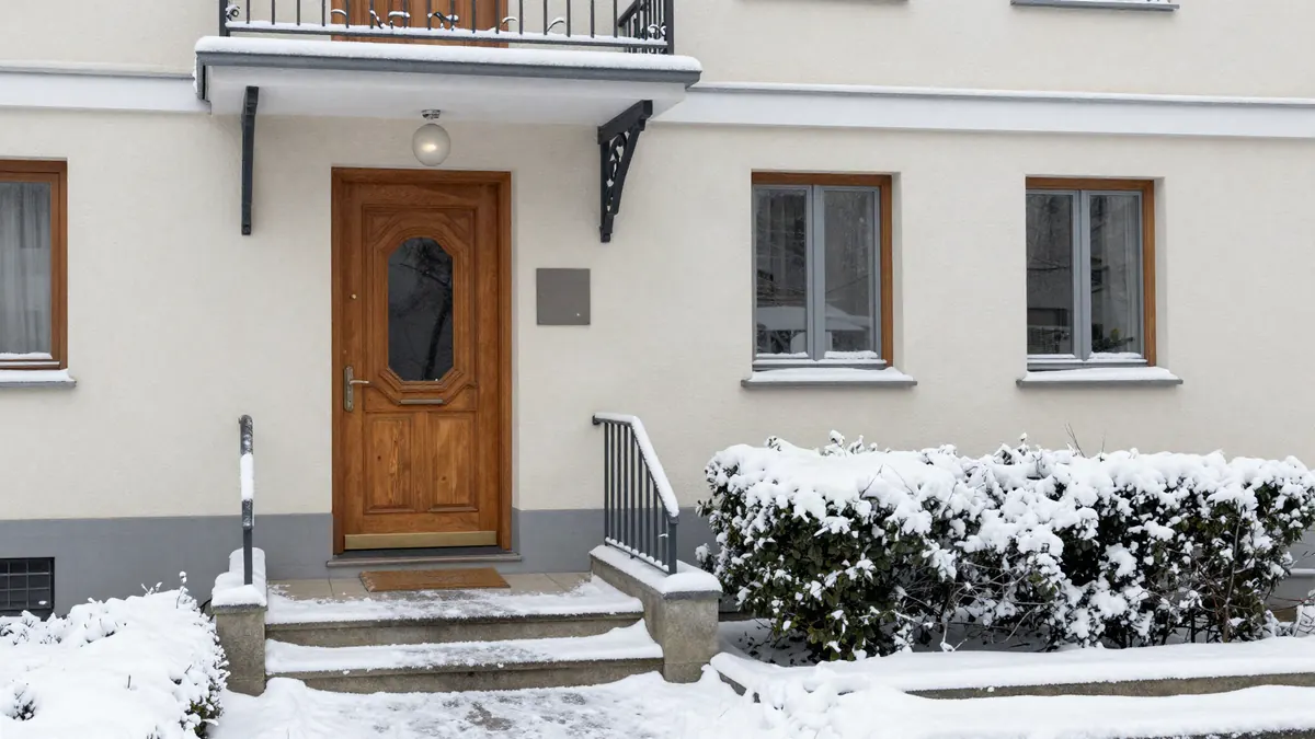 Gemeinschaftseigentum: Hauseingang und Zuweg einer Wohnanlage im Winter